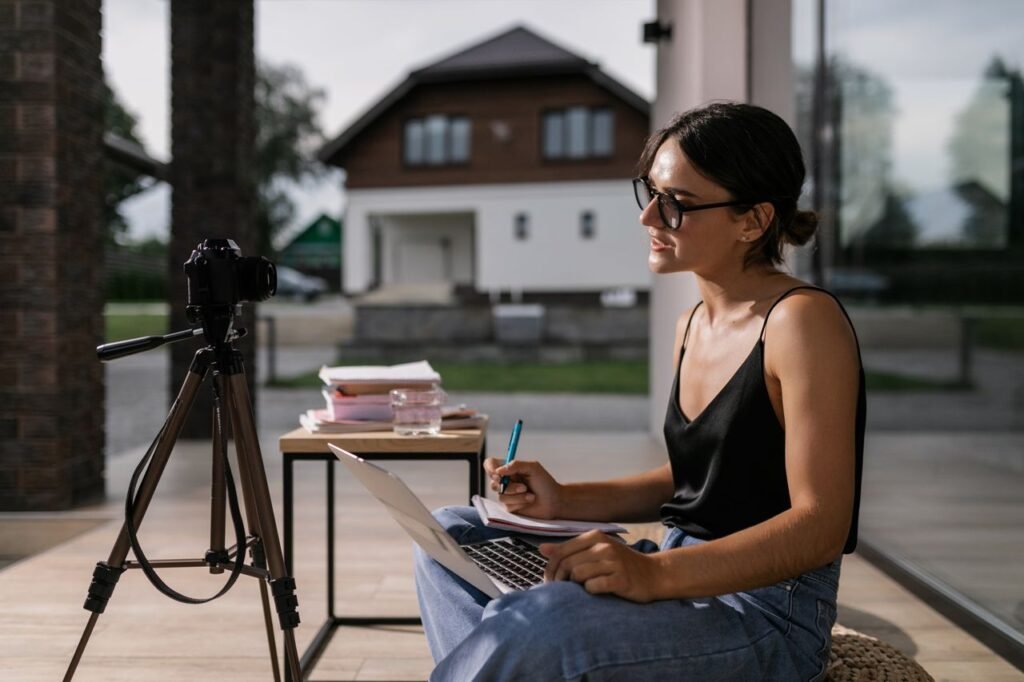 Crafting Captivating Headlines: Your awesome post title goes here Woman sitting with laptop taking notes for an online class, intense focus outdoors.